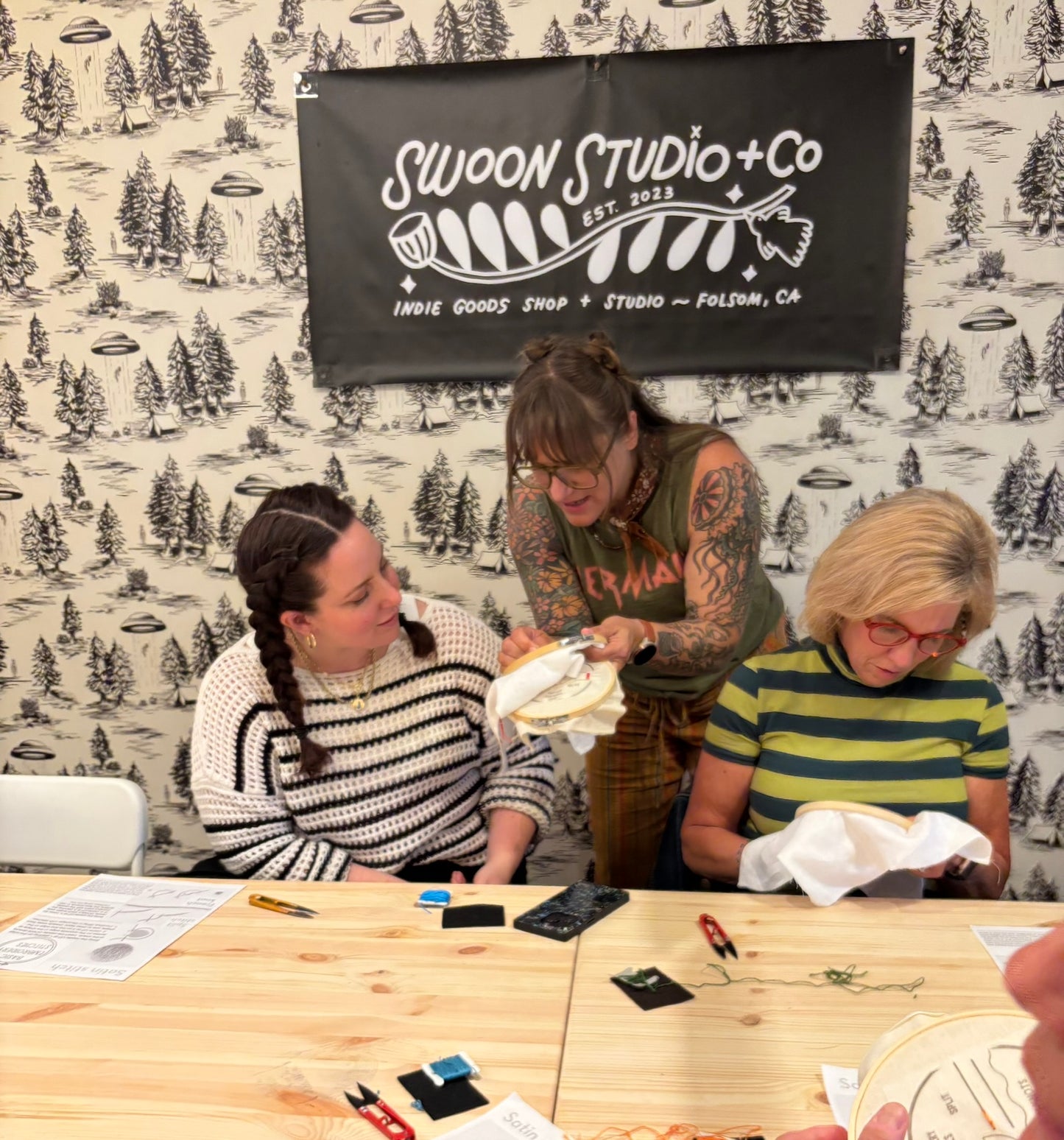 Three women sitting around a table with a 'Swoon Studio + Co' banner in the background.